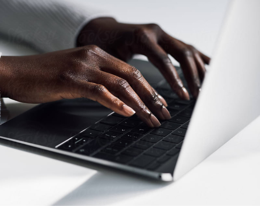 Close up of woman's hands typing on laptop, focused and determined.