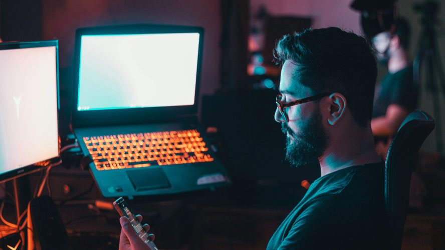 A bearded man working on a computer.