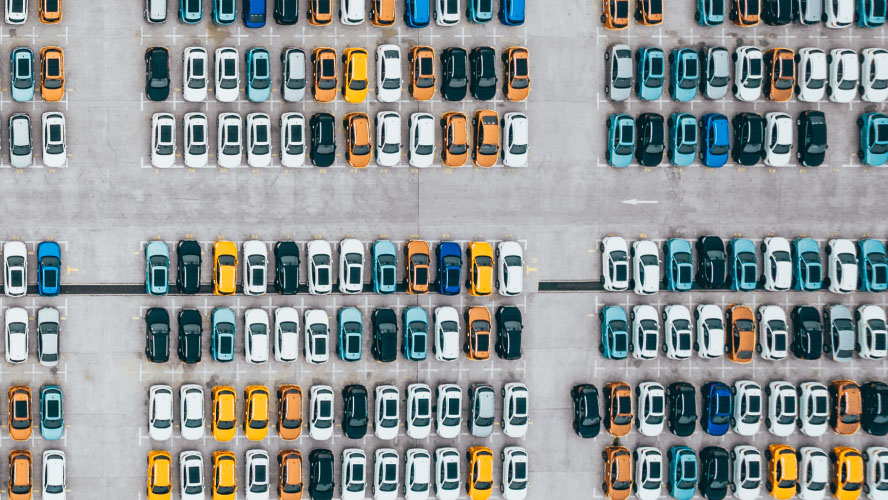 An aerial view showcasing a bustling parking lot filled with numerous parked cars, presenting a vibrant scene of urban mobility.