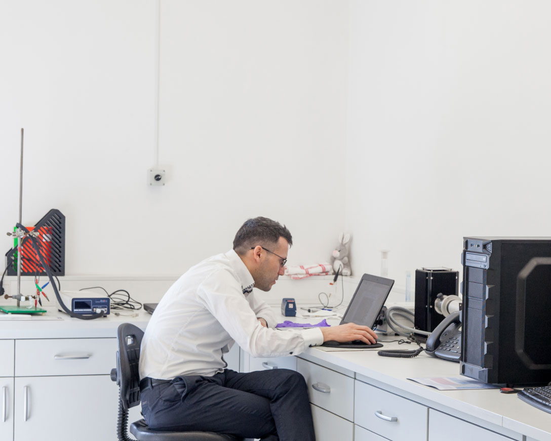 A man sitting on a chair in an office environment.