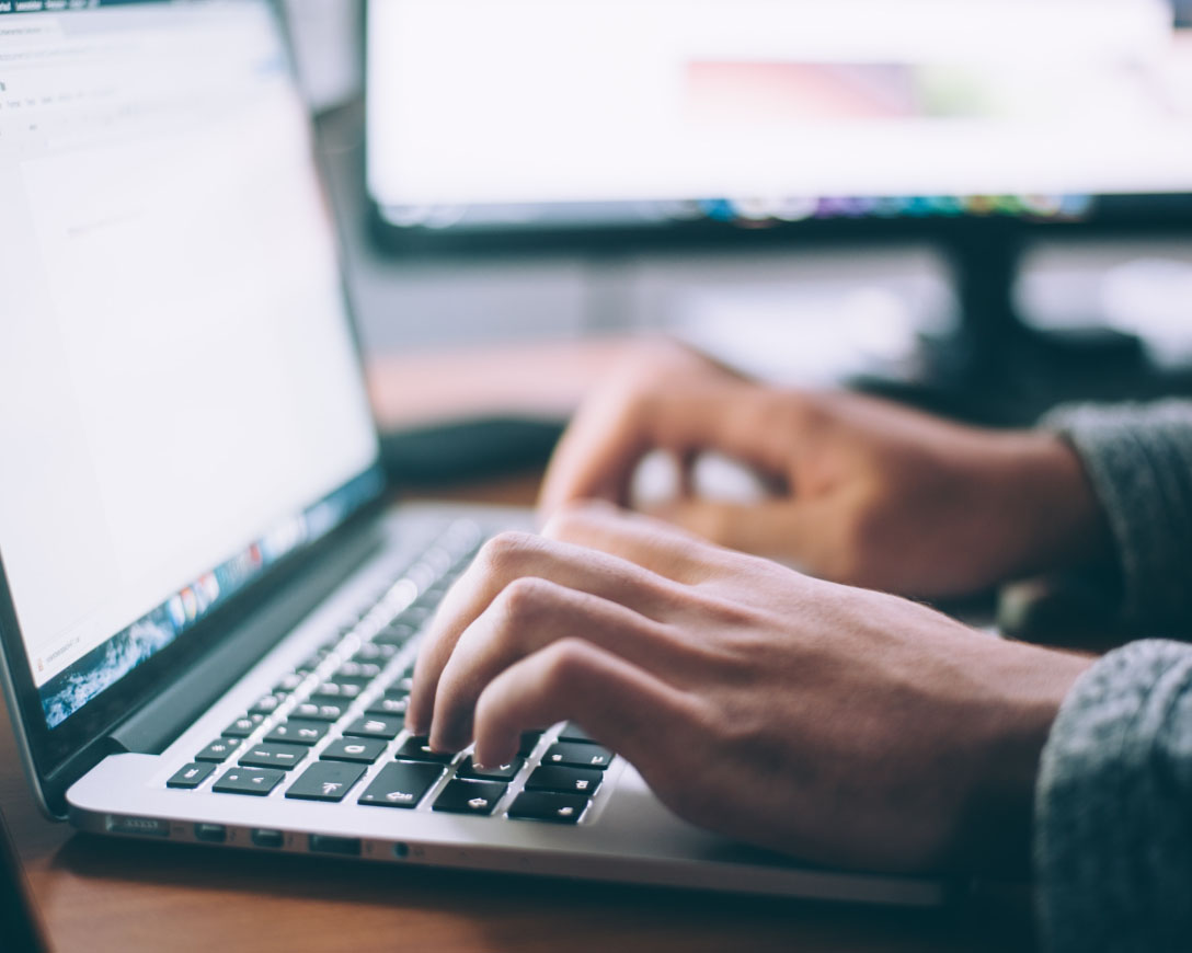 A person typing on a laptop computer.