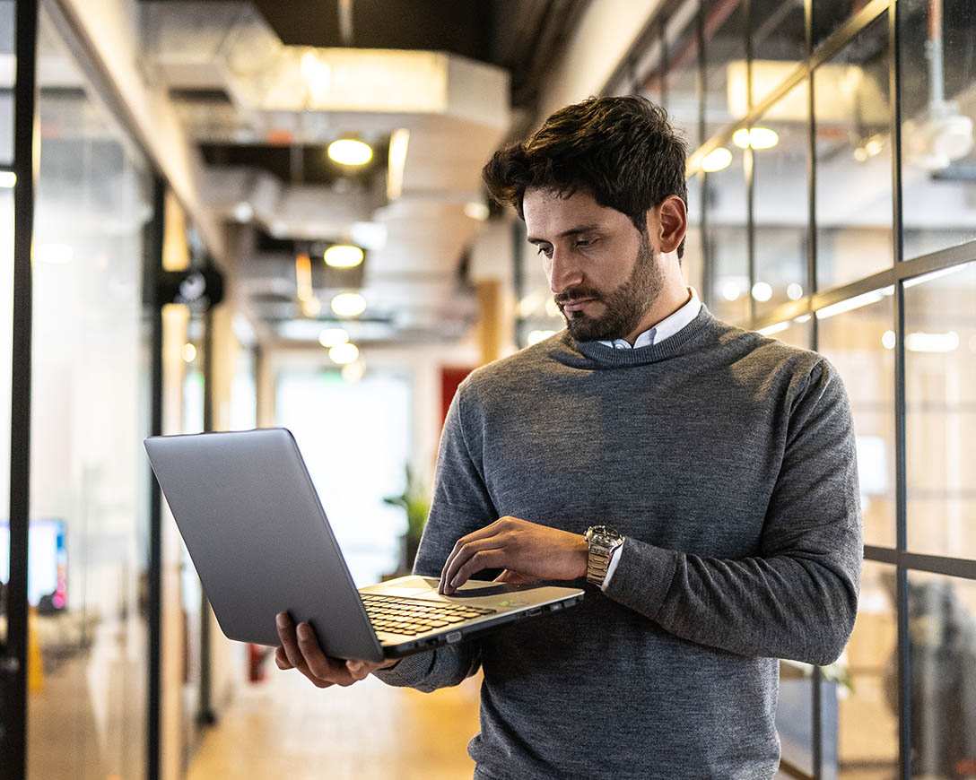 Integrated Security – Businessman using laptop in the corridor at office